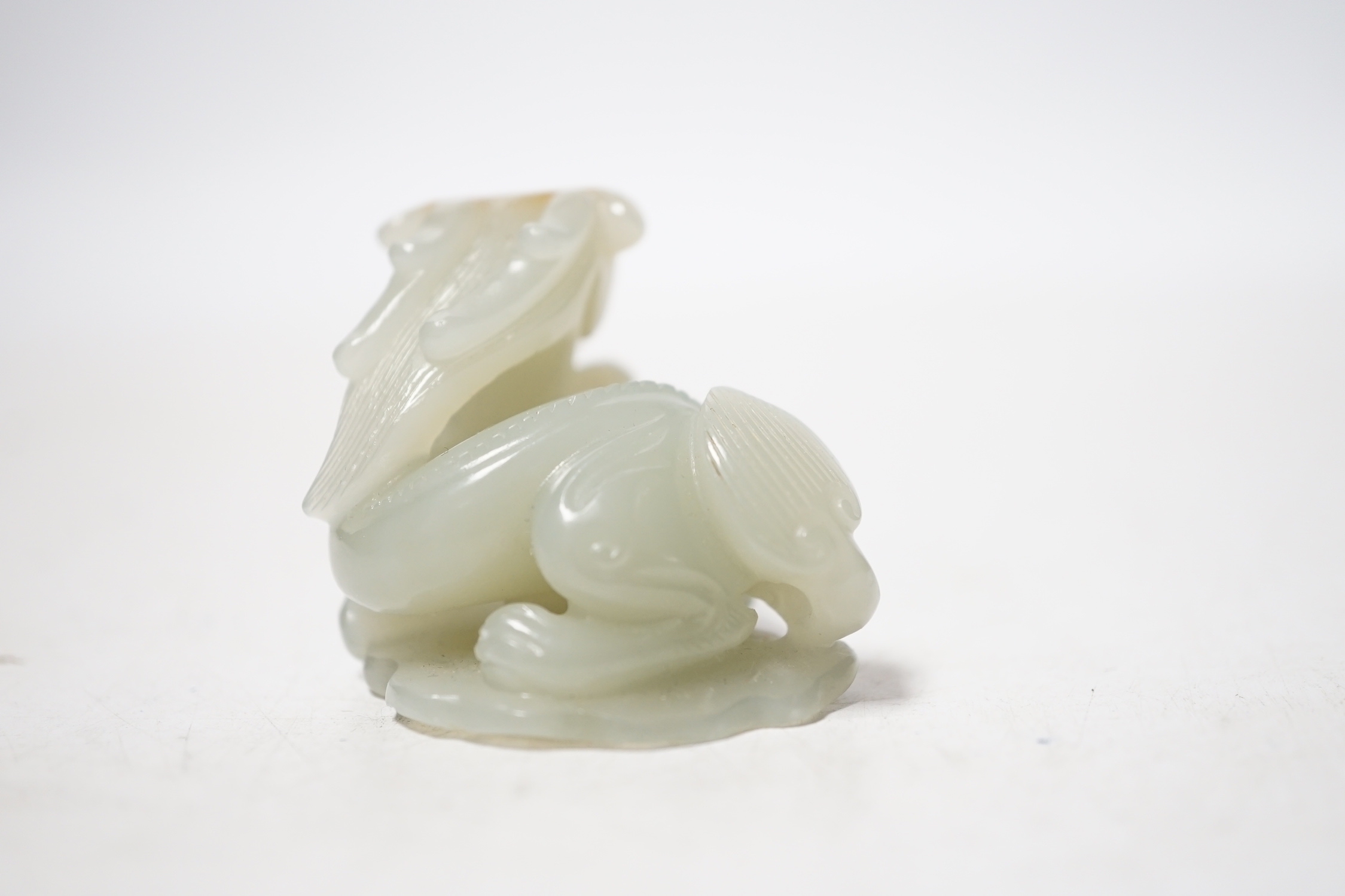 A Chinese pale celadon and russet skin jade figure of a dragon, 4cm high